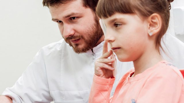 Göz muayenesi sırasında optik cihazla kontrol edilen bir çocuğun net görme değerlendirmesini gösteren görsel.